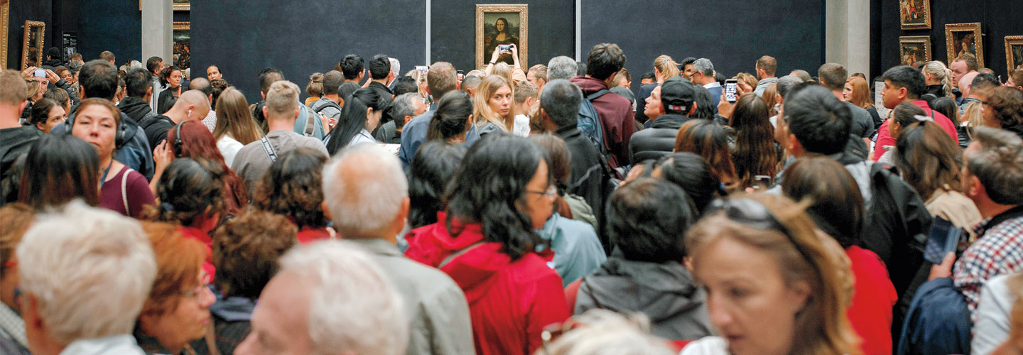 A crowd of people looks at the Mona Lisa.