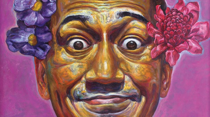 Image of a man&apos;s vibrantly painted face smiling hugely with flowers in his hair